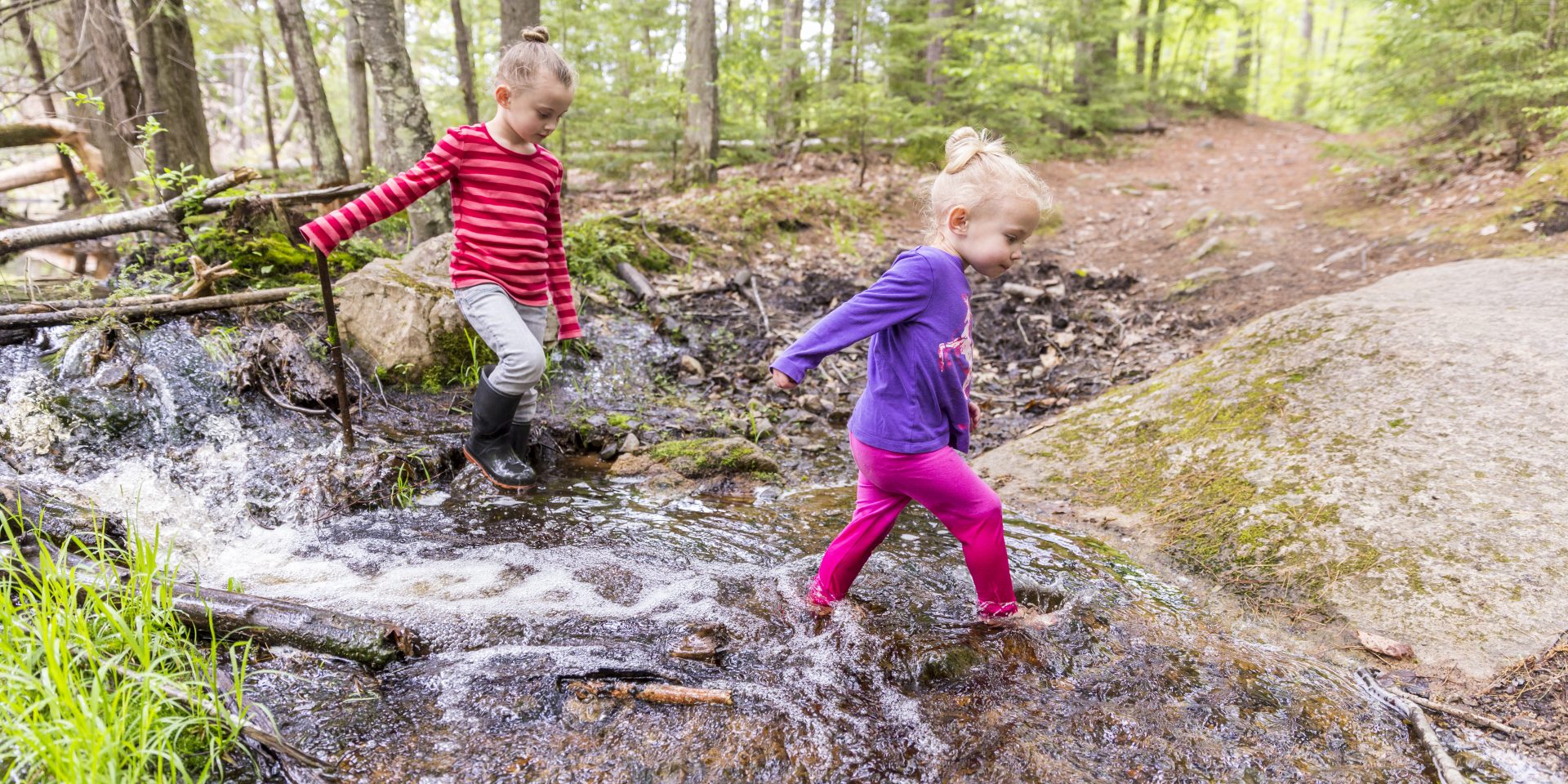 Two young girls play in the woods at the Orris Falls Preserve in South Berwick, Maine.
